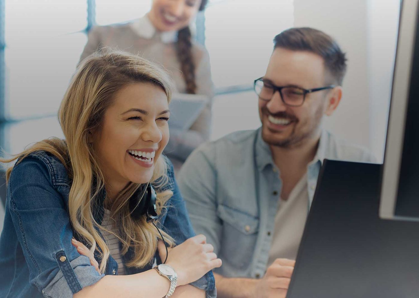 Two Fidelity Group colleagues smiling at a laptop